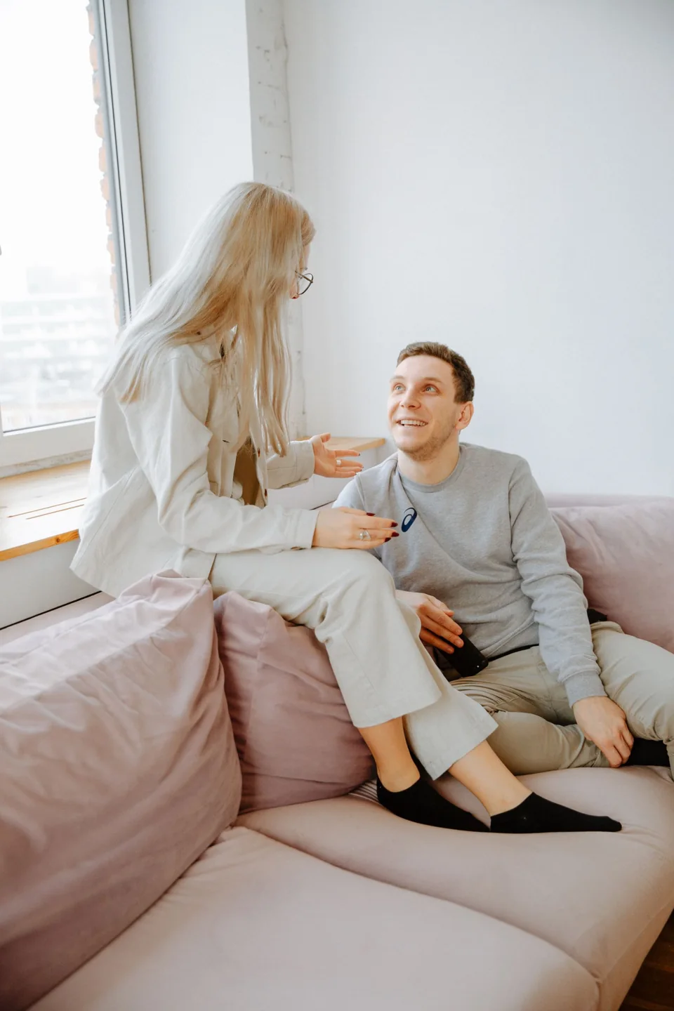 Deux adultes assis près d’une fenêtre prennent le temps d’échanger.